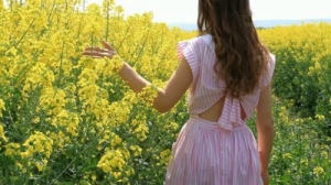 stock-footage-young-woman-in-vintage-dress-walking-down-path-yellow-flowers-spring-field-hd